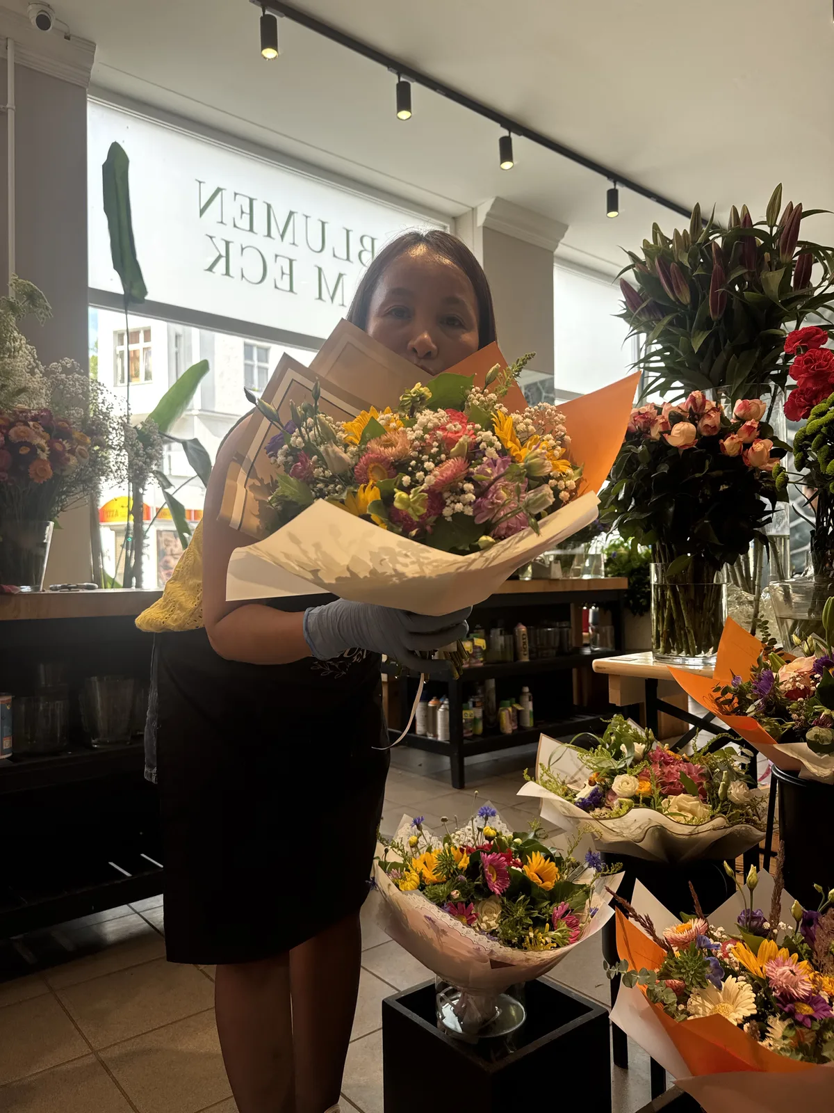 Floristin von Blumen am Eck mit einem frisch gebundenen Sommerstrauß